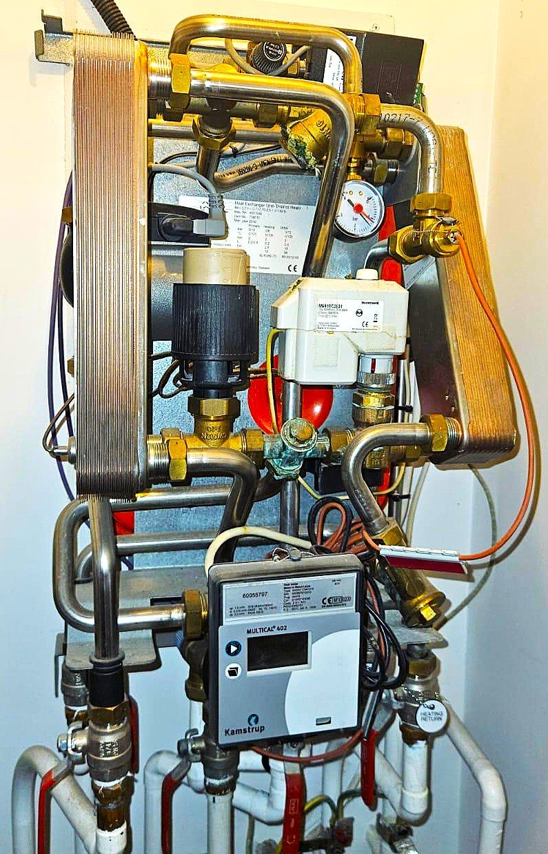 HIU unit installation and pipe connections inside apartment plant room in London